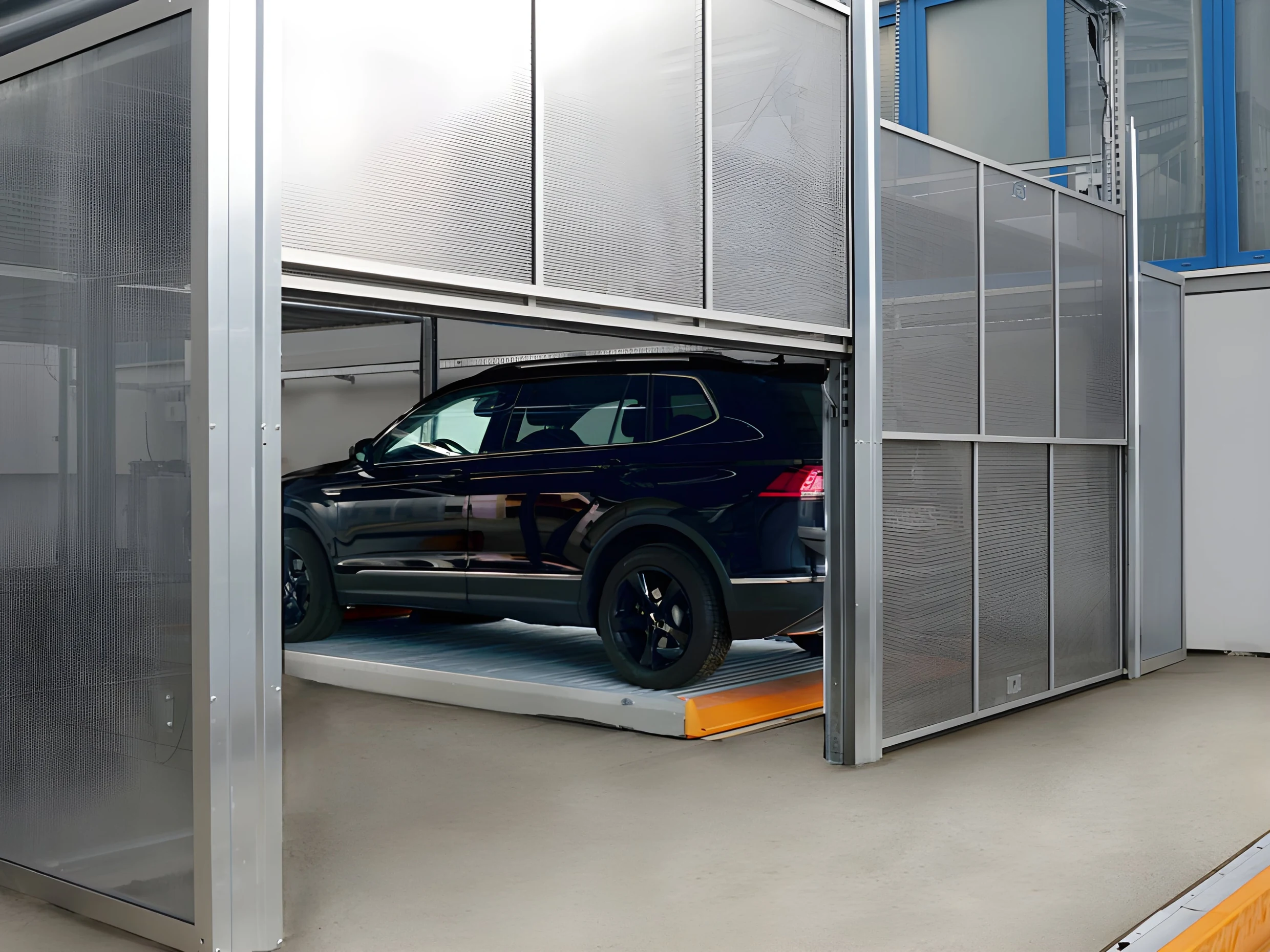 Zaključana kapija poluautomatskog parking sistema sa panelom od perforiranog aluminijuma, vozilo parkirano iza nje